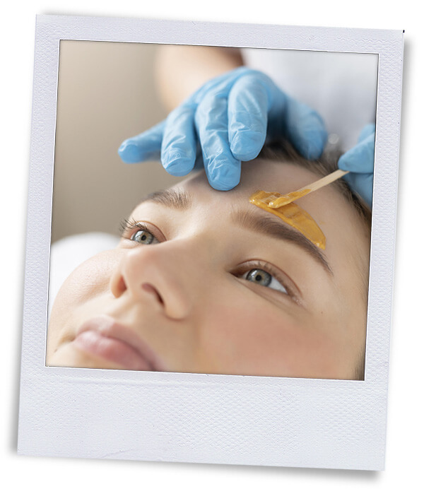 polaroid applying hair removal wax to a persons brow